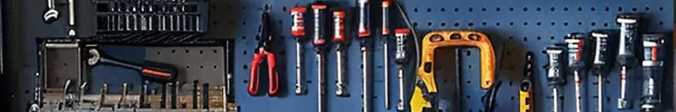 Hand tools hung on a pegboard: wrenches, pliers and screwdrivers.